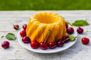 Taze ve olgun kiraz bahçesinde bir tablo ile lezzetli pasta. 