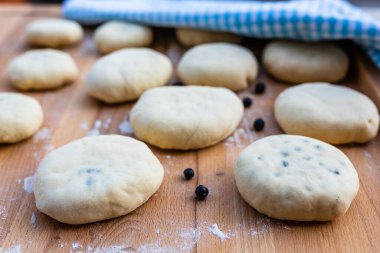Tahtada taze toplanmış yaban mersinli ev yapımı çiğ hamur köftesi..
