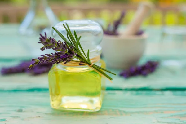 Homemade lavender flower oil on a wooden table.