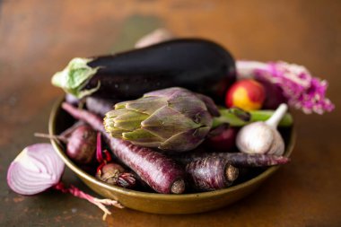 Enginar ve mor sebzeler eski kasede. Sonbahar hasadından sebzeler.