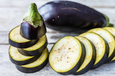 Tahta zemin üzerinde taze dilimlenmiş olgun patlıcan..