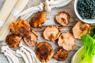 Ahşap zemin üzerinde taze mantar ve miso çorbası için malzemeler..