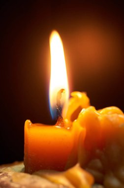 Karanlık odada yanan sarı mum.