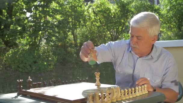 Alter Grauhaariger Mann Bereitet Das Schachspiel Draußen Garten Tisch Vor — Stockvideo