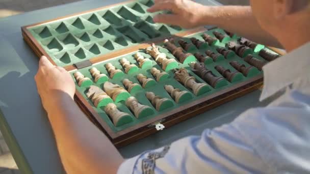 Γέρος Ανοίγει Κουτί Σκακιού Έξω Στον Κήπο Πάνω Στο Τραπέζι — Αρχείο Βίντεο