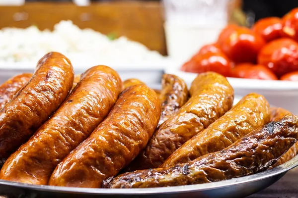 Freshly cooked sausages on a grill close-up. A background of sau — Stock Photo, Image