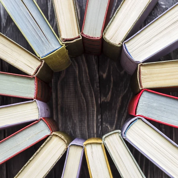 Ahşap bir masa üzerinde renkli kitap yığını. ha okuma kavramı