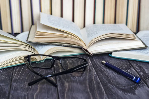 Ahşap bir masa üzerinde renkli kitap yığını. ha okuma kavramı