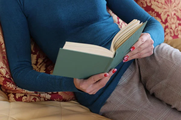 Beautiful girl is reading a book in the bedroom, on the bed. con — Stock Photo, Image