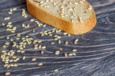 Bir buğday gr üstüne ahşap bir arka plan üzerinde çavdar ekmeği bir parça