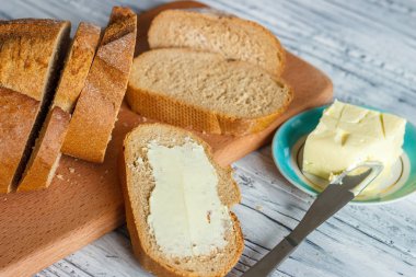 Ahşap bir arka plan üzerinde tereyağı ile çavdar ekmeği bir dilim bir clo olduğunu