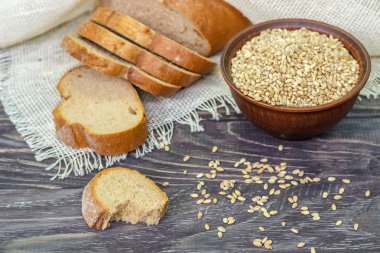 Ahşap bir backgro üzerinde buğday tohumu ile kepekli ekmek dilimleri