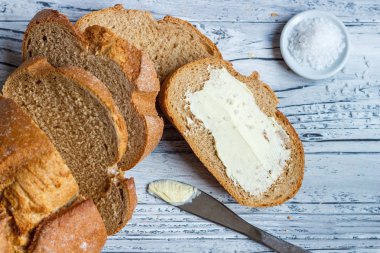 Ahşap bir arka plan üzerinde tereyağı ile çavdar ekmeği bir dilim bir clo olduğunu