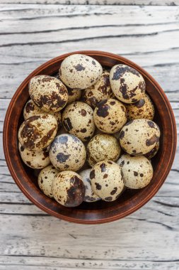 Ahşap bir arka plan üzerinde bir kil plaka bıldırcın yumurta, s için bir tabak