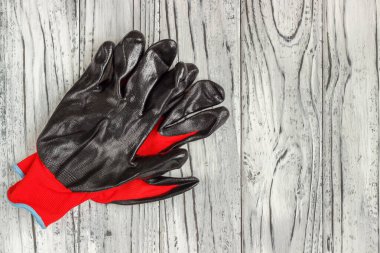 Kişisel koruma ekipmanları: ahşap bir sırtta siyah eldivenler