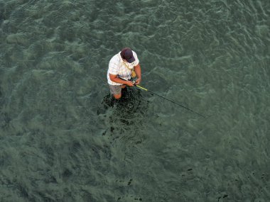 Balıkçı suda duruyor