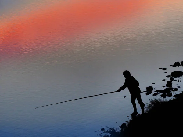Bir Balıkçı Gölde Bir Çubuk Ile Siyah Silüeti — Stok fotoğraf