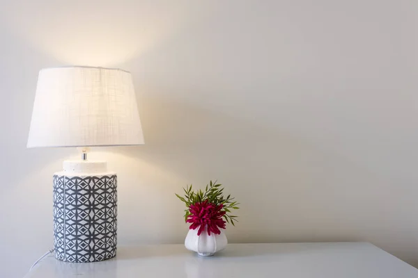 Schöne Blumen Mit Tischlampe Über Weißem Wandhintergrund — Stockfoto