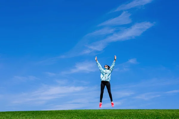 Hübsche Junge Frau Springt Auf Grünem Rasen Über Blauen Himmel — Stockfoto