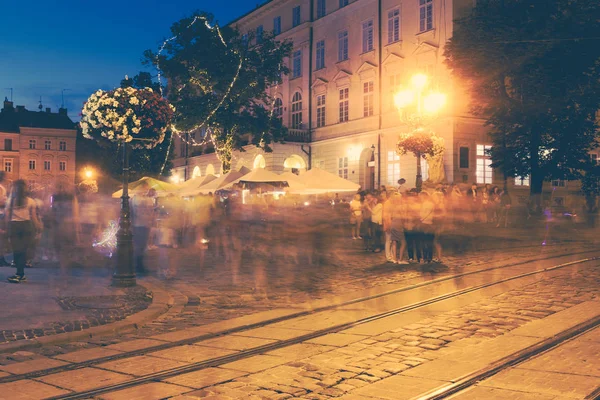 通り古いヨーロッパの都市の夜に動いている人々 の群衆デフォーカスぼやけ抽象イメージ — ストック写真