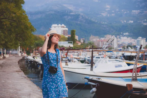 古い地中海の街の海辺でカメラと歩いている若い魅力的な陽気な旅行少女 夏旅行の概念 — ストック写真