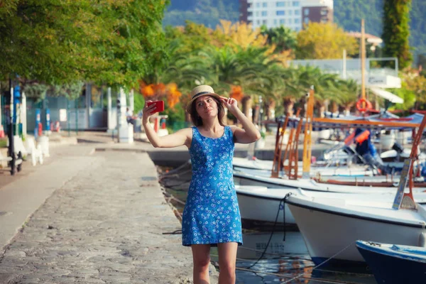 スマート フォンのカメラで夏の日当たりの良い地中海の街で Selfie 写真を撮って帽子の若い旅行女 ブルネットの少女の夏休みの写真を作る — ストック写真