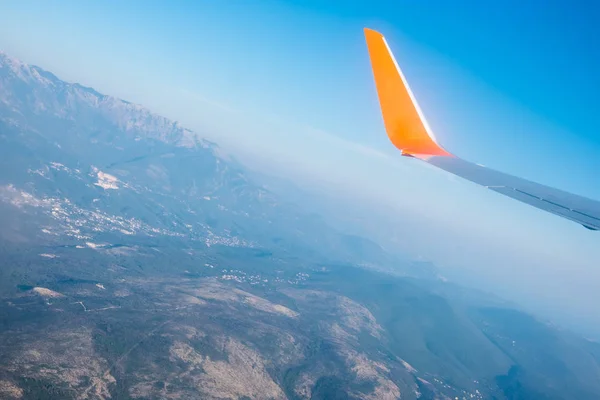 Skrzydła samolotu w błękitne niebo i scena widok gór. Podróże i przygody. — Zdjęcie stockowe