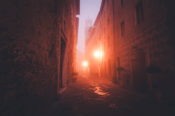 Oude Europese smalle lege straat van een middeleeuws stadje op een mistige avond. Pienza, Italië — Stockfoto