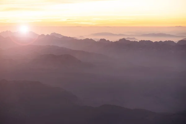 Mistige ochtend in de bergen van de Italiaanse Alpen. Gebergte silhouttes luchtfoto. — Stockfoto