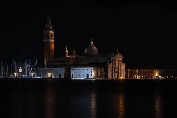 Benátský průplav s historickými budovami a gondolami v noci. Itálie. — Stock fotografie