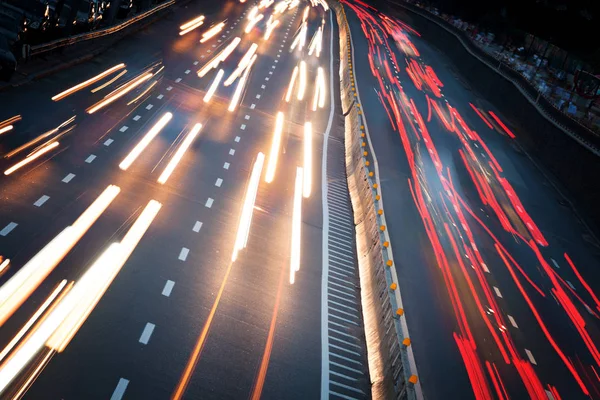 Los senderos ligeros del coche en la carretera en la ciudad moderna de la noche —  Fotos de Stock