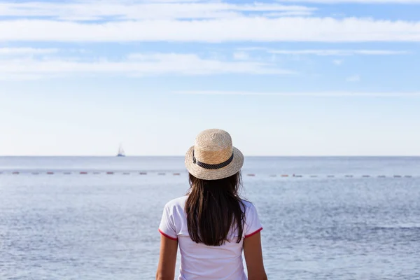 Hermosa chica mira al mar. Chica joven en un sombrero mirando — Foto de Stock