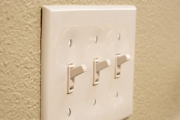 Traditional North American toggle white house electric light switch in ON position on aged old wood wall — Stock Photo, Image