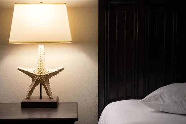 Confortevole camera d'albergo. Lampada sul tavolo vicino al letto — Foto Stock