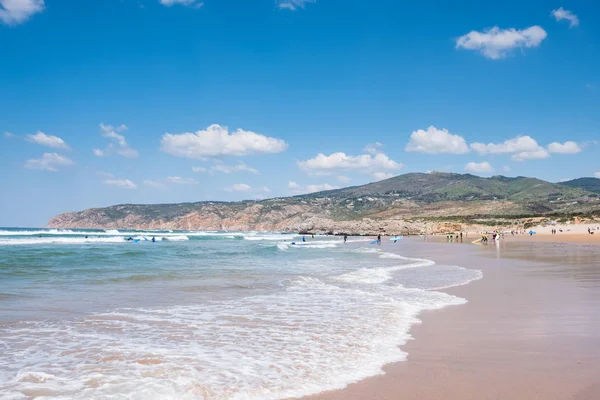 Persone non identificate con tavola da surf sulla spiaggia estiva e acqua blu dell'oceano. Spiaggia estiva vista panoramica — Foto Stock