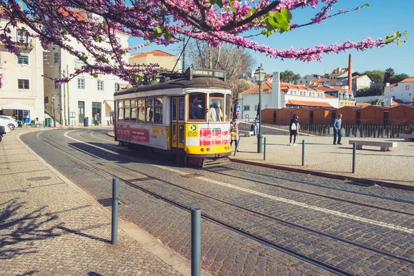 Lisboa, Portugal - 23 de marzo de 2019: Tranvía amarillo, símbolo de Lisboa en la calle soleada con turistas a pie — Foto de Stock