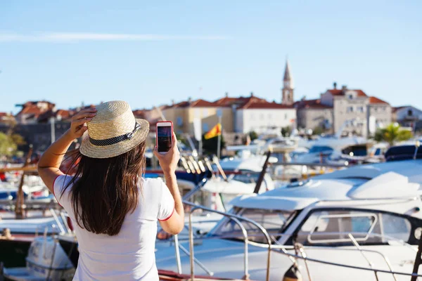 Mujer joven viajando en sombrero tomando fotos de verano mar soleado — Foto de Stock