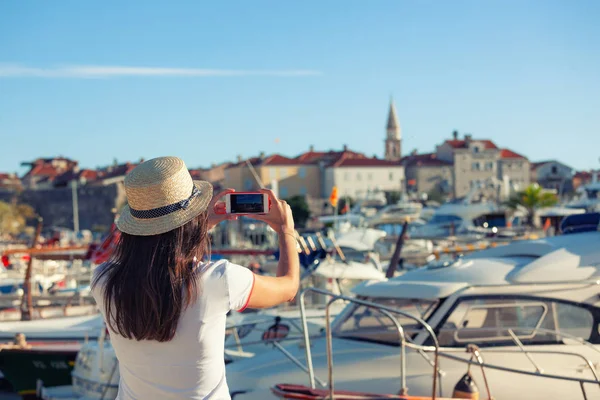 Mujer joven viajando en sombrero tomando fotos de verano mar soleado — Foto de Stock