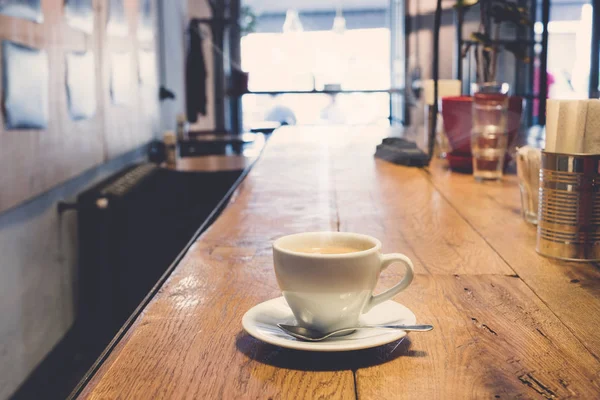 Witte kop koffie in het café-interieur — Stockfoto
