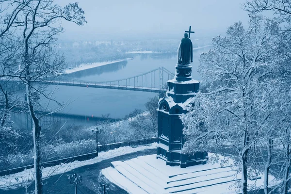 Illuminated bronze statue of Saint Volodymyr in winter Kyiv. Frosted Dnieper river and foot bridge at background. Ukraine — Stock Photo, Image