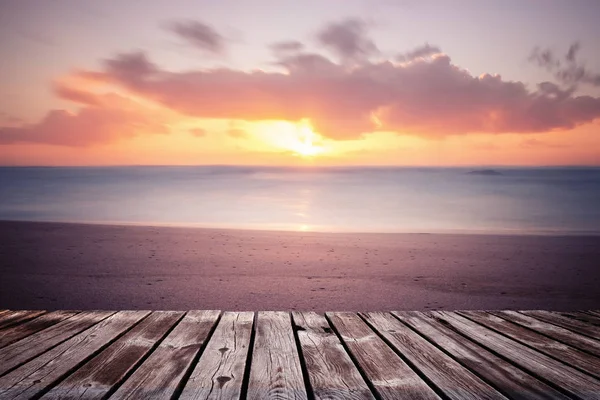 Kleurrijke prachtige bewolkte zonsondergang over de oceaan met houten pad — Stockfoto
