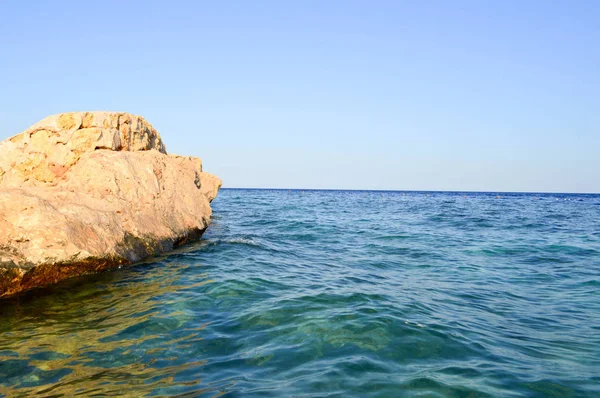 一个巨大的美丽的黄色沙岩 一块石块浸入盐水海蓝色的水对天空 — 图库照片