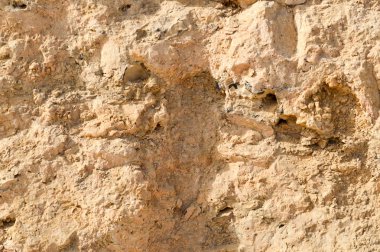 Duvar dokusu sarı kumlu kayrak eski çürümüş taş, kaya parçaları, delik ve katmanları ile yapılır. Arka plan.