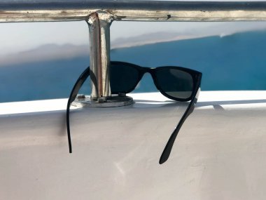 Mavi deniz ve dağlar karşı bir yat, bir cruise liner bir demir korkuluk siyah plastik güneş dayan.