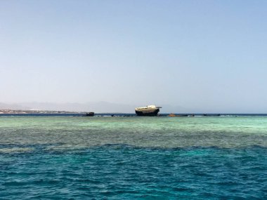 Büyük bir gemi, bir liner, mavi bir tuz denizi güzel bir manzara zemin karşı mercan resifleri bir enkaz sonra kırık bir tanker.