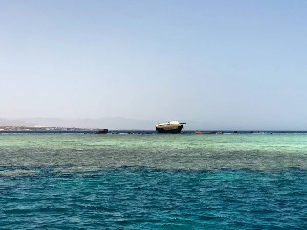 Büyük bir gemi, bir liner, mavi bir tuz denizi güzel bir manzara zemin karşı mercan resifleri bir enkaz sonra kırık bir tanker.