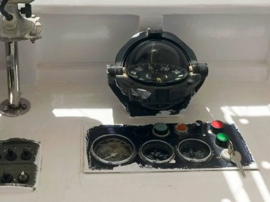 Gösterge paneli üzerinde bir tekne, gemi, deniz taşımacılığı ile bir yuvarlak siyah pusula, takometre, hız göstergesi, kontak anahtarı ve düğme.