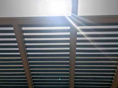Güneşte tahtalar ile kirişler delikleri ile açık havada modern tasarımcı çatı.