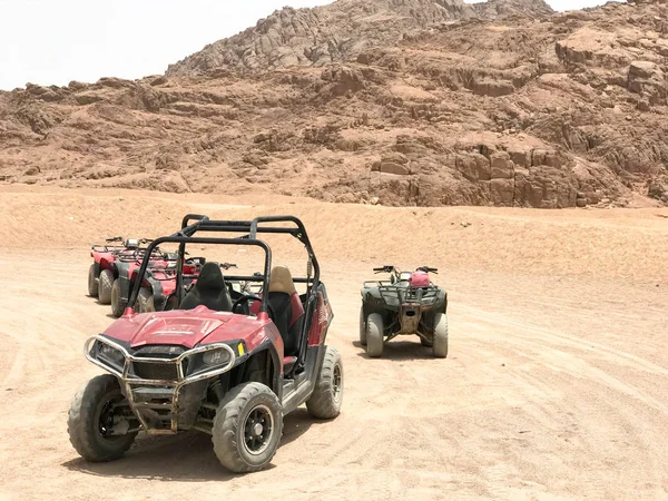 Dört tekerlekli çok renkli güçlü hızlı off-road dört tekerlekten çekiş arabaları, Araba, SUV'lar yüksek dağlar çerçevede Park yerinde kum üzerinde sıcak kumlu çölde bir sürü.
