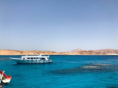 Beyaz Yatlar, tekneler, gemiler denize yelken, dağların arka planına karşı mercan resifleri ile mavi su ile okyanus ve Mısır bayrağı.